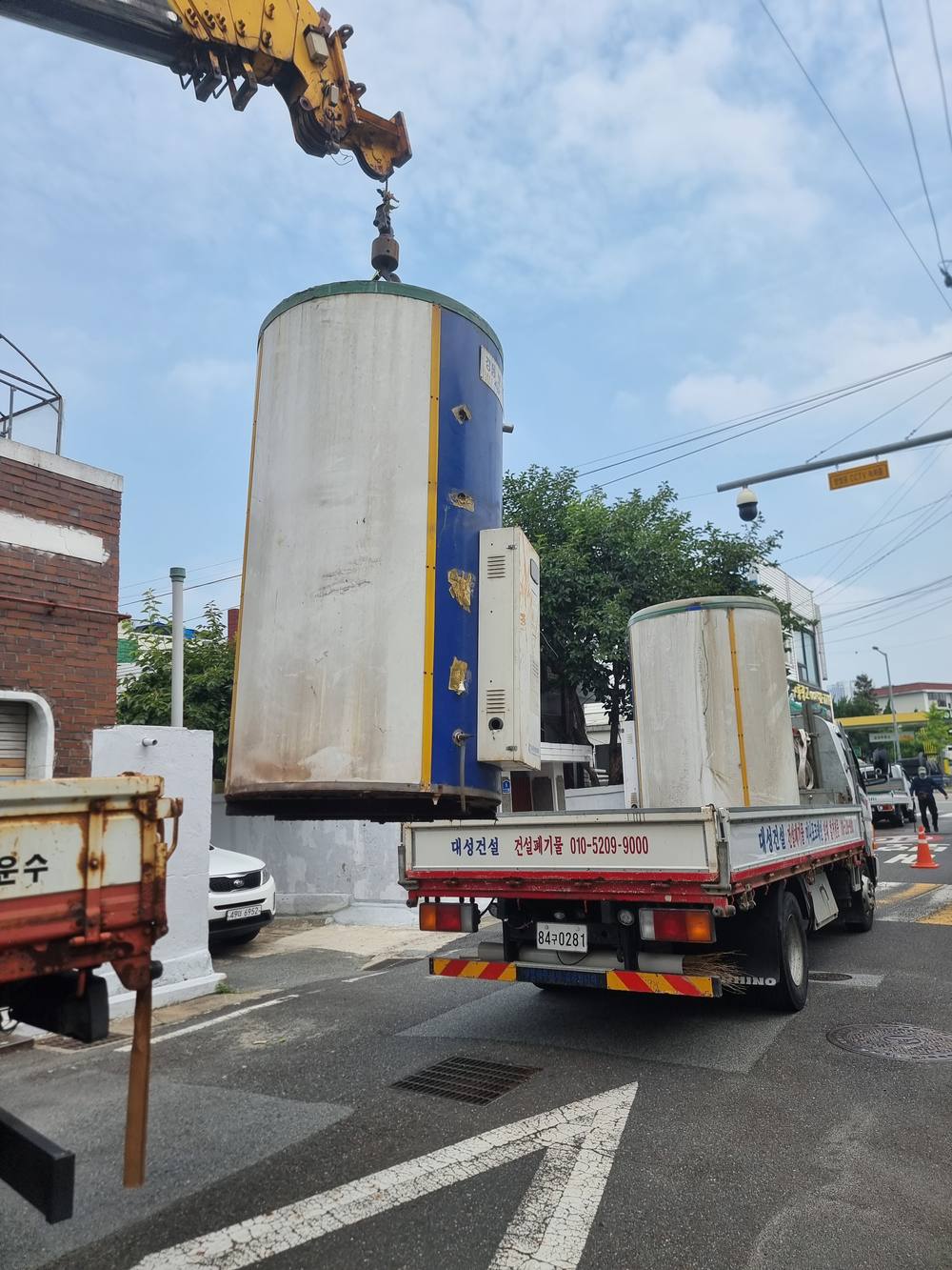 크레인으로 물탱크를 들어올리는 작업 현장