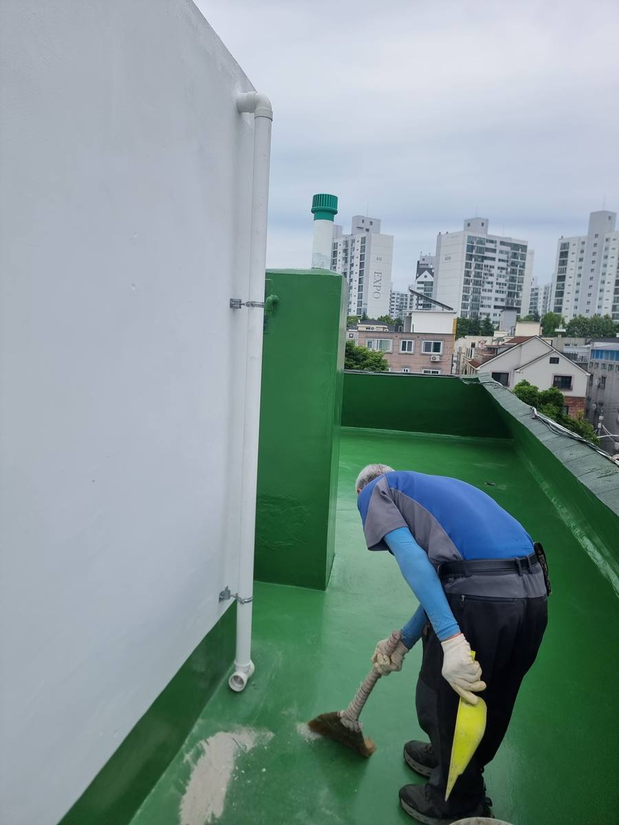 옥상 방수 도장 시공 중인 작업자