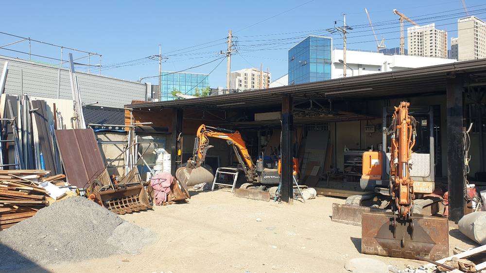 사무실 야드의 굴삭기 2대와 자재